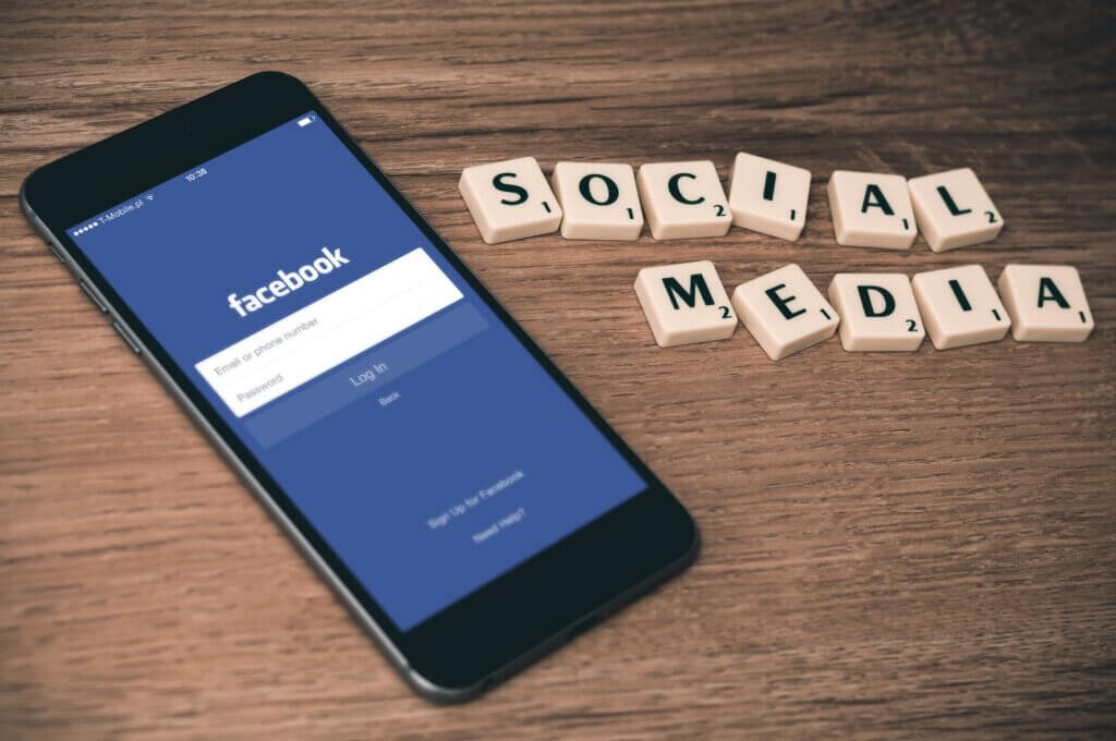 Teléfono móvil con el logo de Facebook y letras de scrabble que dicen Social Media